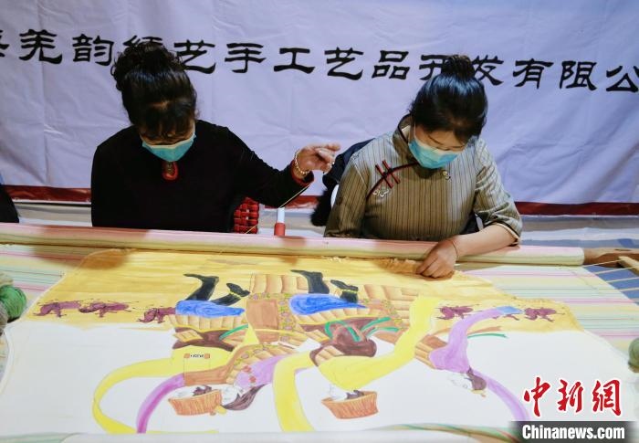 圖為皮繡藝人在市集上“秀”指尖技藝?！●R銘言 攝