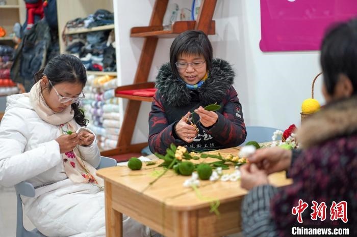 文創(chuàng)工作室的姐妹們正在鉤織月桂葉片。　古良駒 攝