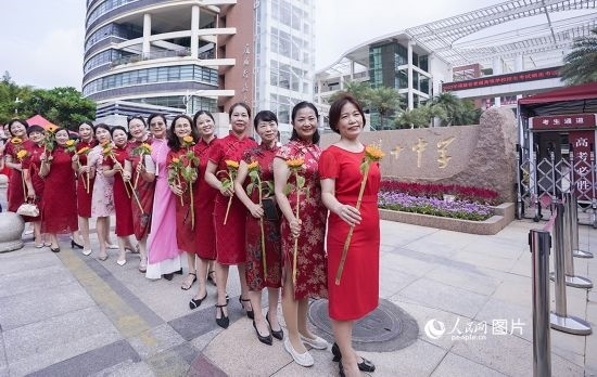 6月7日一早，廈門雙十中學考生家長們身穿旗袍，手拿向日葵在考場外為孩子加油打氣，寓意“旗開得勝，一舉奪魁”。人民網(wǎng)記者 陳博攝