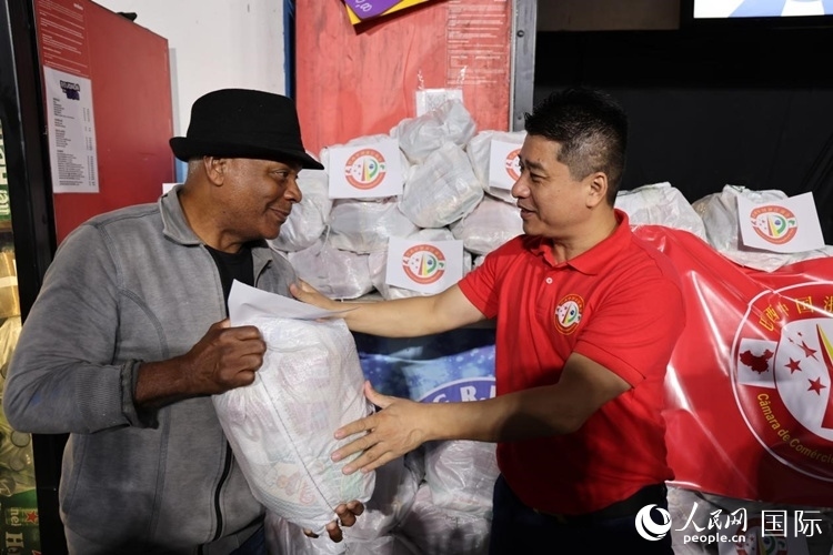 巴西中國浙江商會(huì)會(huì)長鄭俠茂向社區(qū)居民轉(zhuǎn)交捐贈(zèng)物資。人民網(wǎng)記者 時(shí)元皓攝