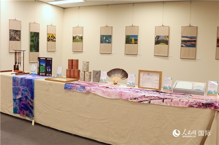 現(xiàn)場展出的馮學(xué)敏攝影作品與湖州市特色工藝品。（人民網(wǎng) 許可攝）