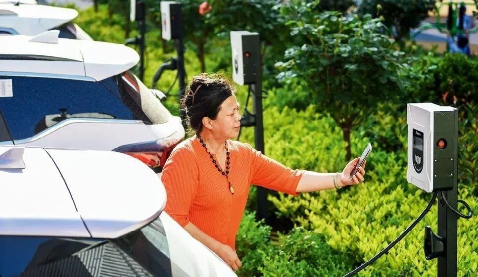 2023年5月24日，山東省膠州市新立街小區(qū)內(nèi)一位居民使用電動汽車充電樁掃碼充電。該小區(qū)加裝各類智慧設(shè)備，打造“智慧社區(qū)”，為居民生活帶來便利。