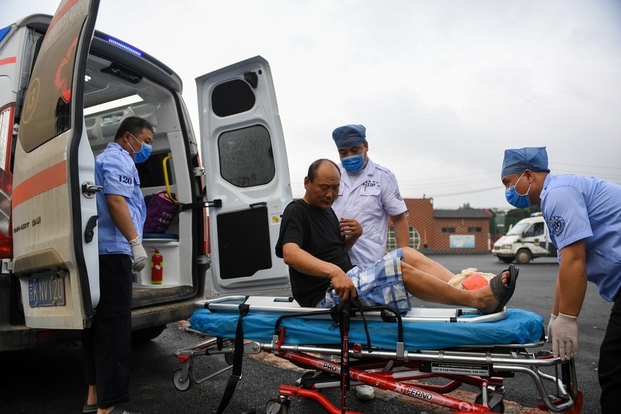 8月1日，在北京市門頭溝區(qū)妙峰山鎮(zhèn)妙峰山民族學校臨時安置點，北京急救中心工作人員在轉運一名受傷村民。新華社記者 鞠煥宗 攝