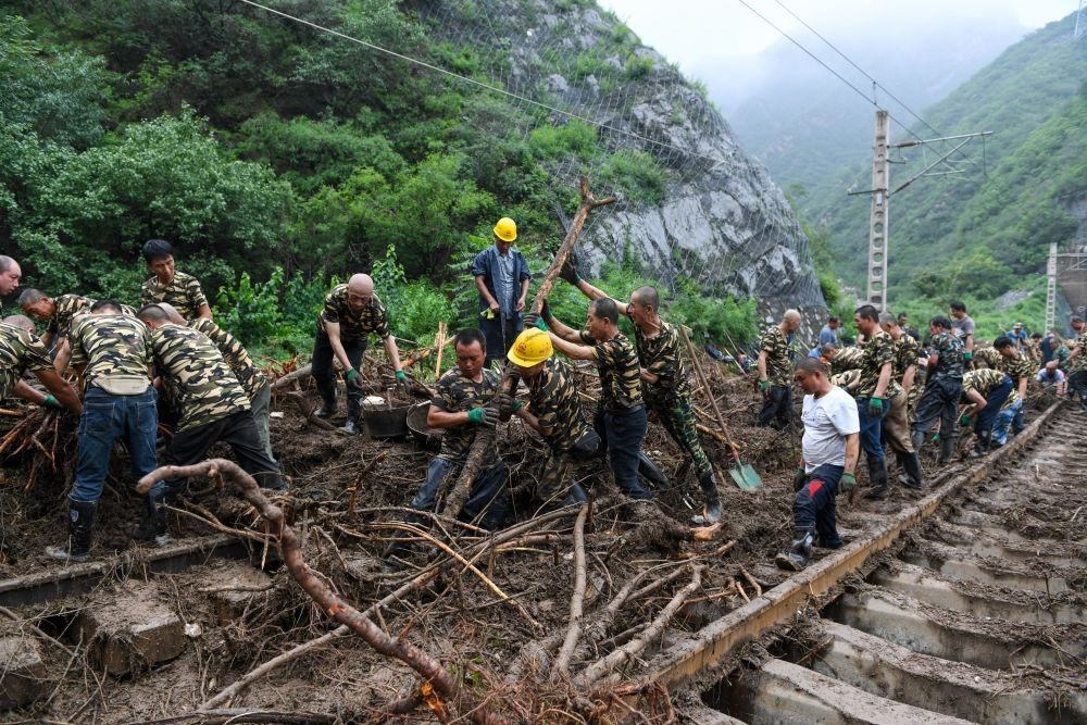 8月1日，在北京市門頭溝區(qū)水峪嘴村附近一段被阻斷的鐵路線上，中鐵六局工作人員在清理軌道上的雜物，全力恢復(fù)交通。新華社記者 鞠煥宗 攝