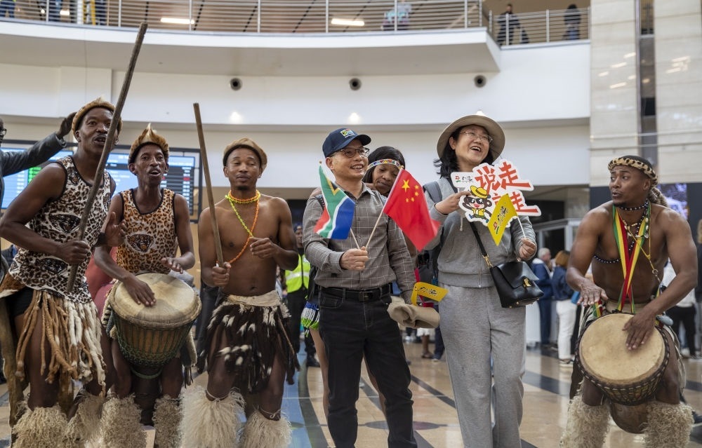 在南非約翰內(nèi)斯堡坦博國際機場，南非舞蹈演員歡迎中國試點恢復(fù)出境團隊旅游后首批抵達南非的中國游客（2023年3月29日攝）。