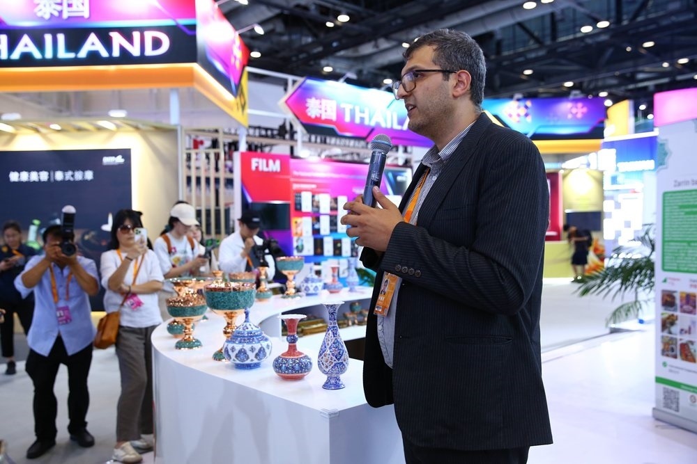 9月1日，參展商在國家會議中心向媒體記者介紹展臺信息。新華社記者 孫瑋彤 攝