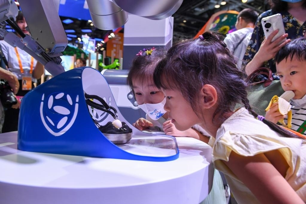 9月3日，幾名小朋友在國家會議中心觀看單孔腔鏡手術機器人展示。新華社記者 鞠煥宗 攝