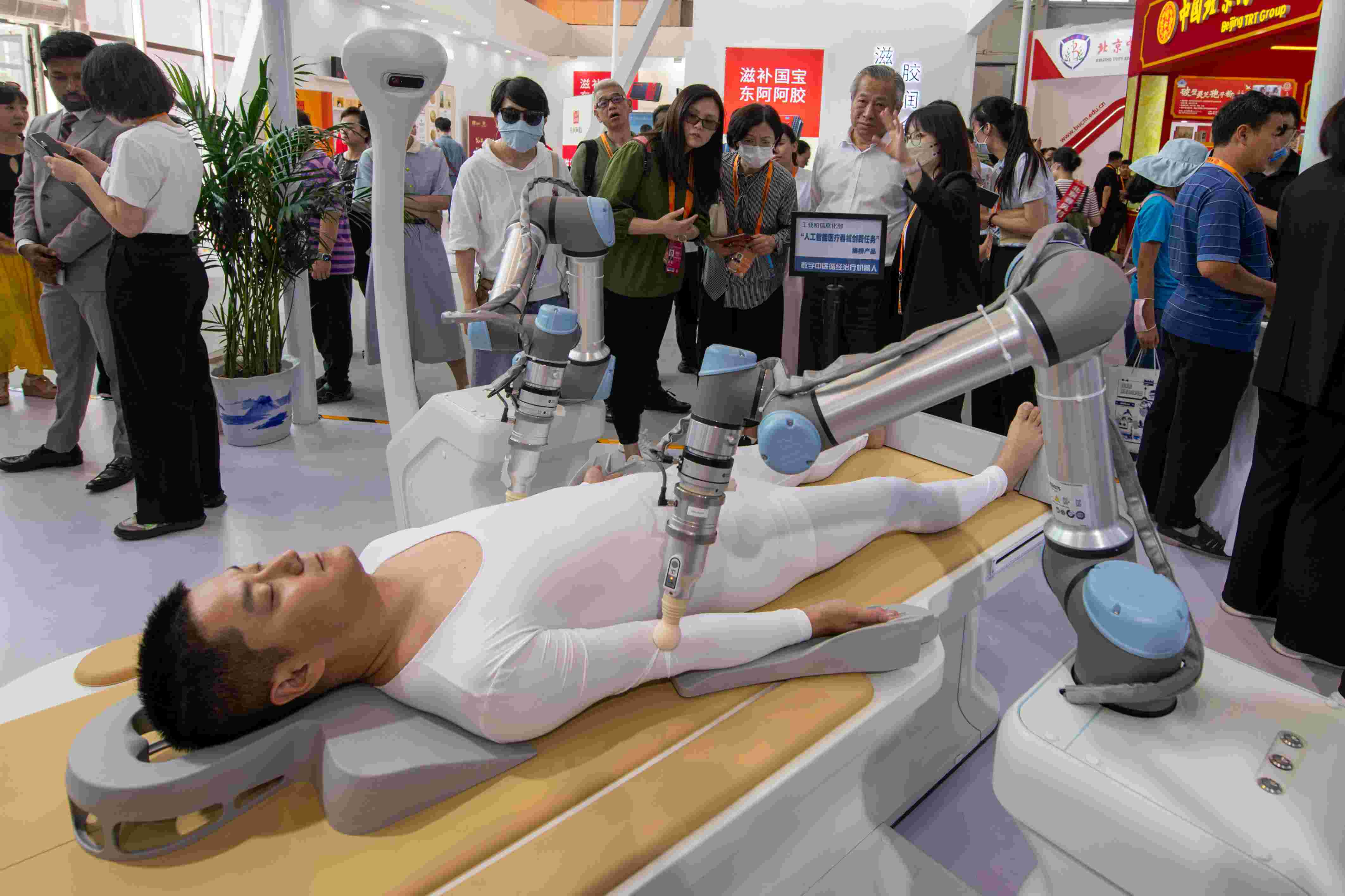 在位于首鋼園的健康衛(wèi)生服務(wù)展區(qū)，觀眾正在參觀數(shù)字中醫(yī)循經(jīng)治療機(jī)器人。人民網(wǎng)記者 翁奇羽攝