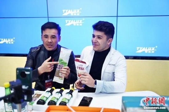 2023年3月，甘肅省慶陽(yáng)市環(huán)縣電商創(chuàng)業(yè)孵化基地內(nèi)，來(lái)自蘭州文理學(xué)院的塔吉克斯坦留學(xué)生正在協(xié)助主播直播帶貨當(dāng)?shù)剞r(nóng)特產(chǎn)品。李亞龍 攝