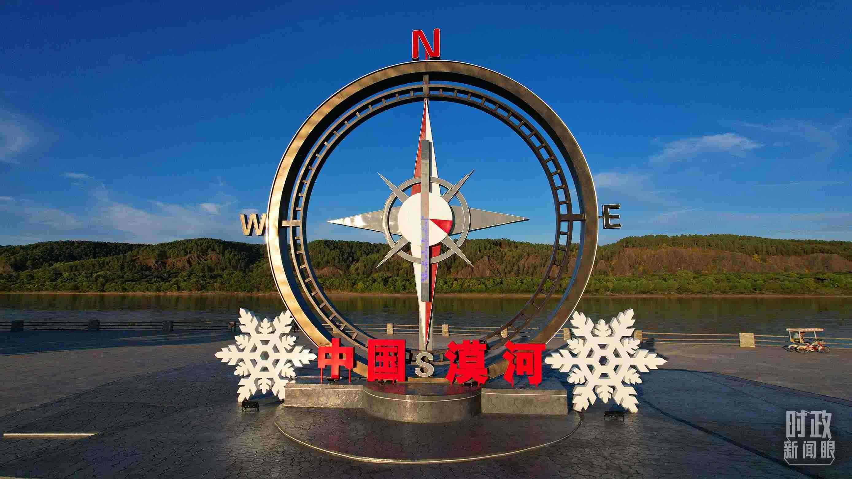 △指北針雕塑是北極村標志性建筑之一，其紅色指針指向正北方。上面的大型溫度計高12.22米，象征北極村位于東經(jīng)122°20′。（總臺央視記者范凱拍攝）