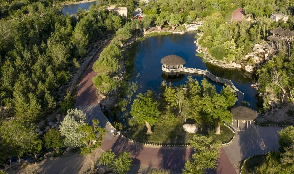 坐落在寧夏銀川市賀蘭山腳下的賀蘭山運(yùn)動(dòng)休閑公園（2021年5月27日攝，無(wú)人機(jī)照片）。這里曾是一片砂石采礦塌陷區(qū)，當(dāng)?shù)赝ㄟ^(guò)植被景觀再造、水系建設(shè)、現(xiàn)代管網(wǎng)鋪建等手段，重新利用廢石、廢坑及各類廢棄建筑材料，把這里變成一座免費(fèi)開放的主題公園。新華社記者 馮開華 攝