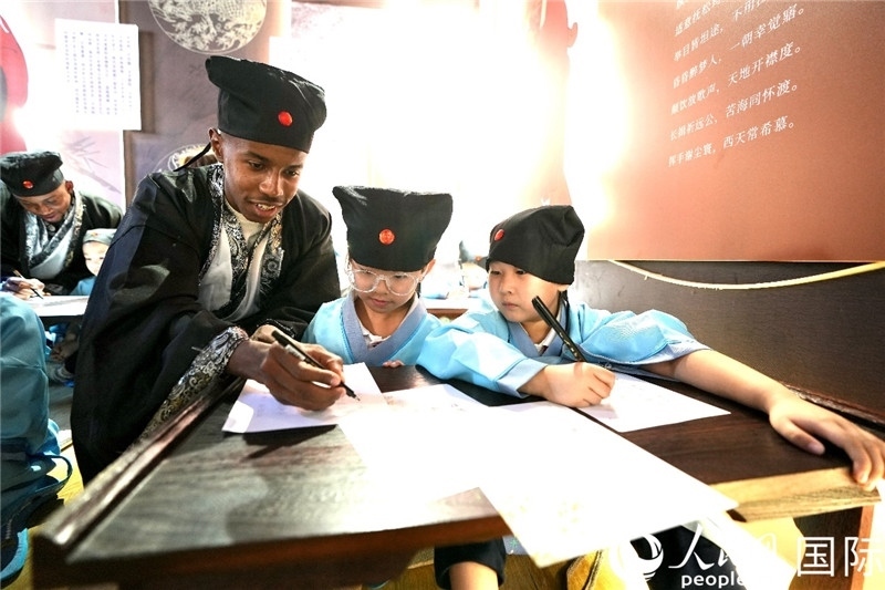 圖為選手與同學(xué)們一起寫書法。人民網(wǎng) 盧鵬宇攝