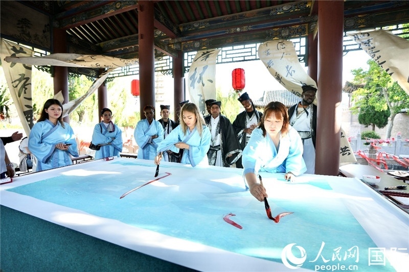 選手們提筆書寫“家園”二字。人民網(wǎng) 盧鵬宇攝