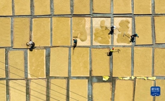 9月16日，在湖南省懷化市通道侗族自治縣萬(wàn)佛山鎮(zhèn)溪上村，村民在晾曬稻谷（無(wú)人機(jī)照片）。