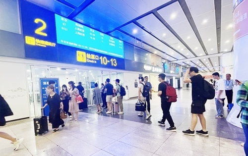 在快速進(jìn)站廳前排隊(duì)等待檢票的旅客。人民網(wǎng)記者 喬雪峰攝