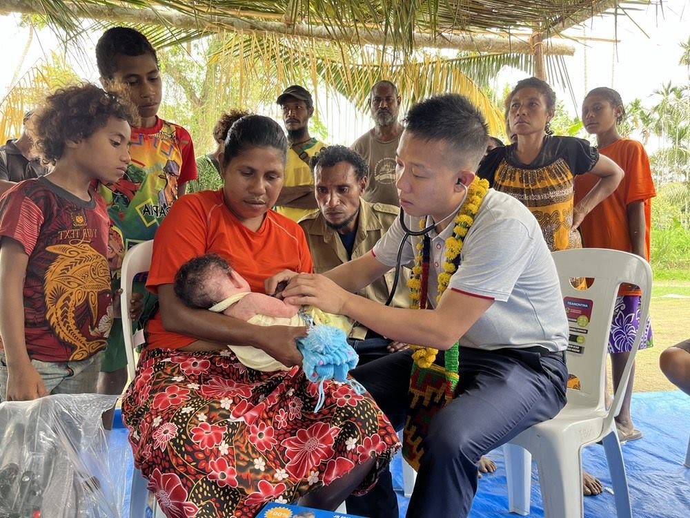 2023年8月5日，在巴布亞新幾內亞中央省的一個村莊里，第12批援巴新中國醫(yī)療隊副隊長、新生兒科副主任醫(yī)師劉振球為當地嬰兒聽診檢查。新華社發(fā)（第12批援巴新中國醫(yī)療隊供圖）