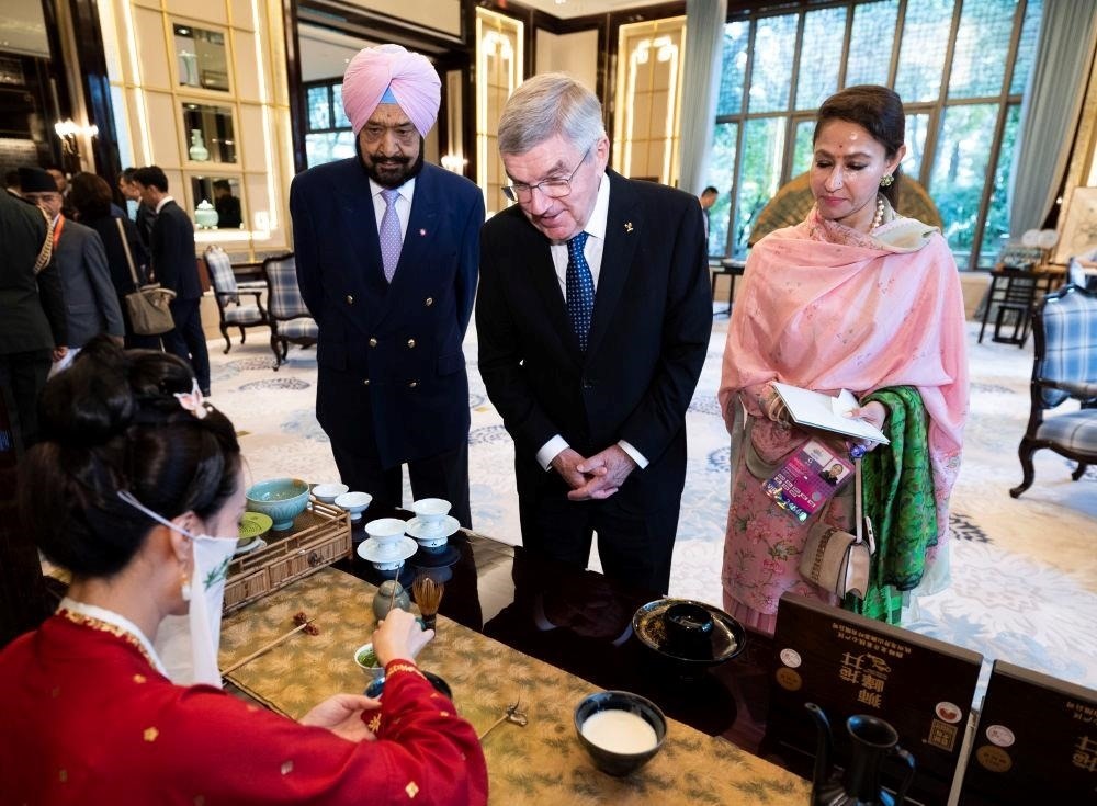 △歡迎宴會前，亞奧理事會代理主席辛格和夫人維尼塔、國際奧委會主席巴赫欣賞非遺展示。