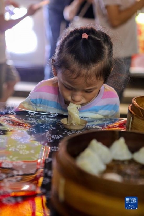 9月27日，小朋友在南翔小籠長(zhǎng)街宴上品嘗南翔小籠。