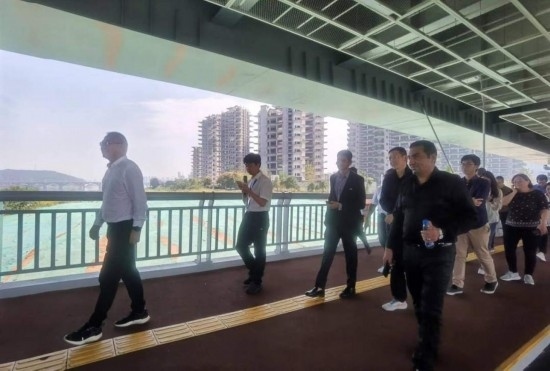 10月24日，2023“一帶一路”媒體合作論壇聯(lián)合采訪團團員走在清水塘大橋景觀通道上。本報記者 常雯宜攝