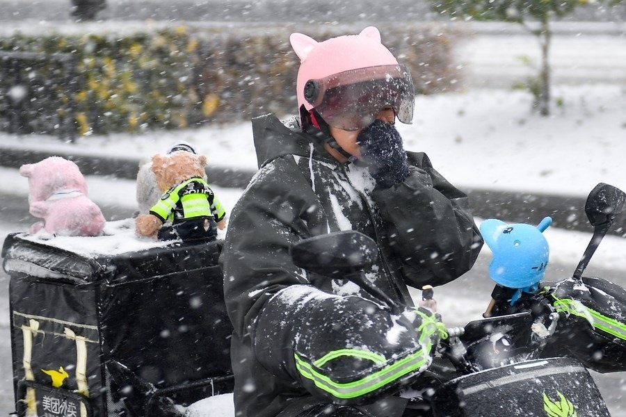 11月6日，在長春市街頭，一名外賣員在雪中騎行。新華社記者 許暢 攝