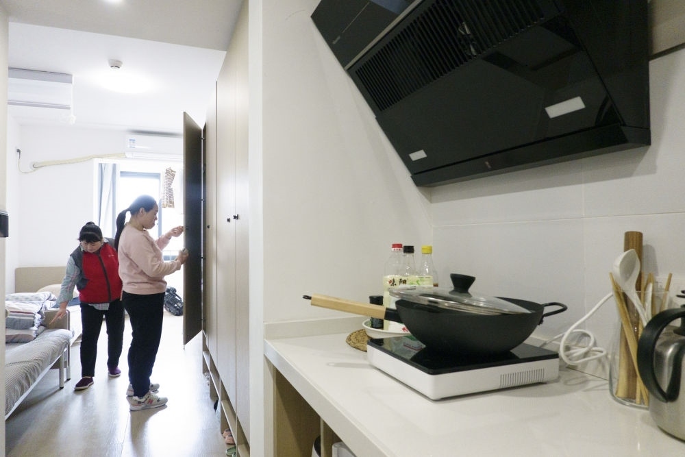 住戶在閔行區(qū)新時代城市建設(shè)者管理者之家收拾房間。