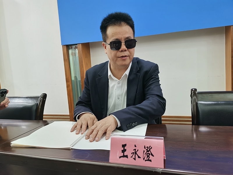 全國人大代表王永澄正在閱讀盲文版代表建議答復。本報記者 張 璁攝