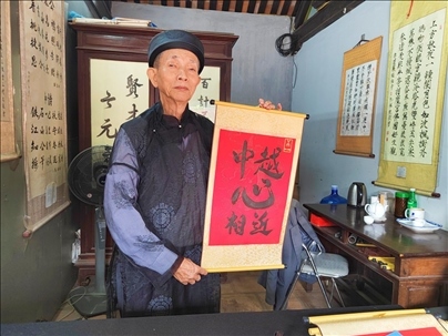 越南首都河內(nèi)文廟內(nèi)，阮明珠展示“中越心相近”書法作品。