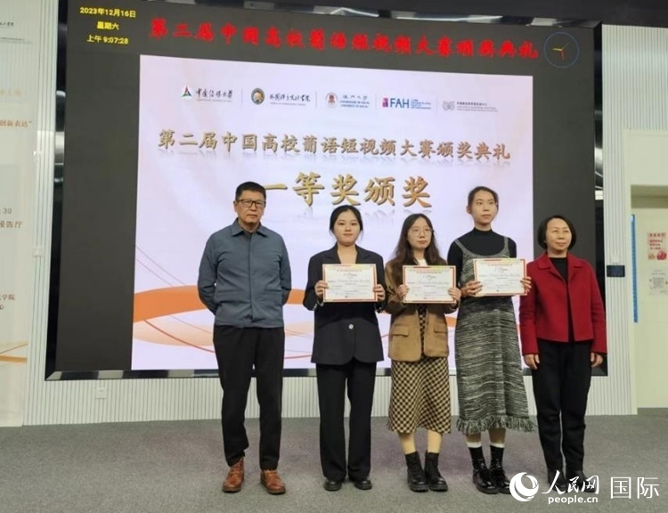 澳門大學(xué)中葡雙語教學(xué)暨培訓(xùn)中心主任姚京明（左一）和中國傳媒大學(xué)外國語言文化學(xué)院院長文春英（右一）為一等獎(jiǎng)獲得者頒獎(jiǎng)。人民網(wǎng)記者 魯揚(yáng)攝