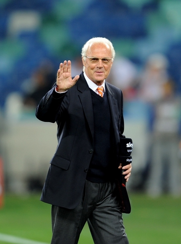 這是2010年7月7日，在南非德班舉行的2010年足球世界杯德國(guó)隊(duì)對(duì)陣西班牙隊(duì)的半決賽前，貝肯鮑爾接受電視臺(tái)采訪時(shí)和友人打招呼。新華社記者 王毓國(guó) 攝