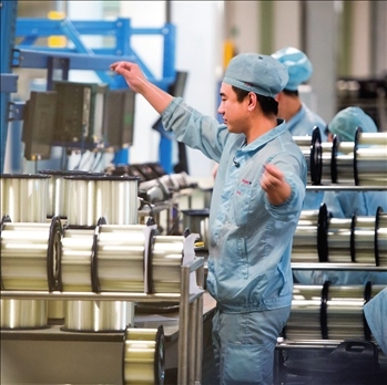 在位于武漢的長(zhǎng)飛光纖光纜股份有限公司光纖生產(chǎn)車間內(nèi)，工作人員對(duì)光纖進(jìn)行檢測(cè)（資料圖片）。肖藝九攝/本刊