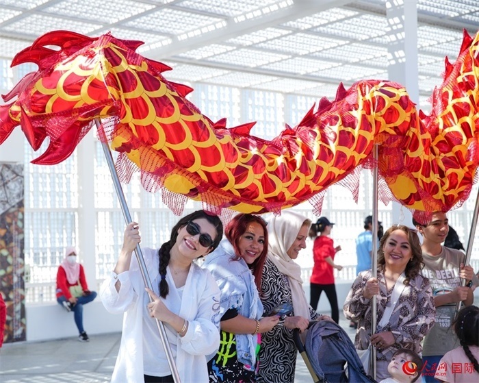 游客體驗舞龍。 人民網(wǎng) 塔里克·易卜拉欣攝