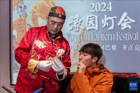 1月28日，在上海豫園舉行的民俗活動(dòng)上，美國(guó)馬斯卡廷中學(xué)學(xué)生在非遺傳承人的指導(dǎo)下吹糖偶。 新華社記者 王翔 攝