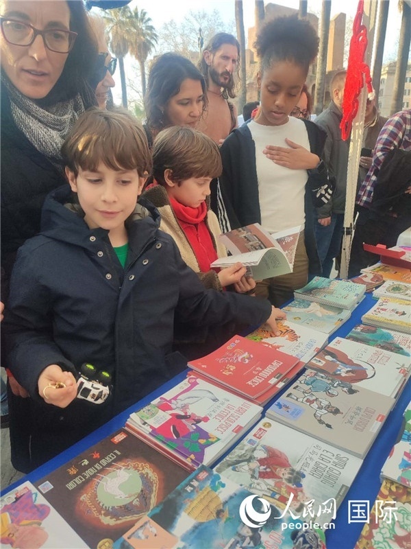 印刷精美的中國傳統(tǒng)文化叢書吸引了小游客的注意。人民網(wǎng)記者鄭彬攝