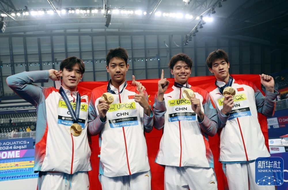 2月11日，2024年多哈游泳世錦賽男子4×100米自由泳接力決賽，中國隊(duì)選手王浩宇、張展碩、季新杰和潘展樂（從左到右）在頒獎(jiǎng)儀式后合影慶祝。新華社記者 雒圓 攝