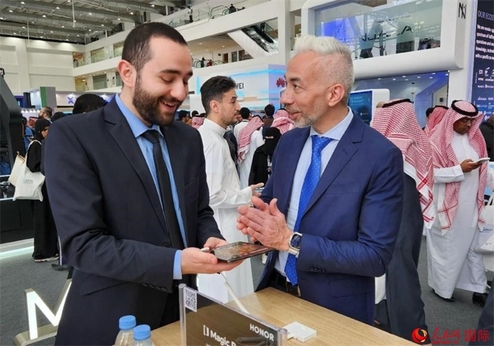 兩名觀眾在榮耀手機(jī)展臺(tái)前交流。人民網(wǎng)記者 管克江攝