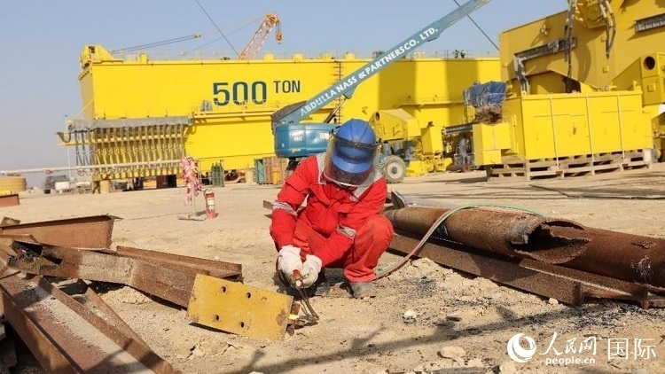 工人正在龍門吊吊裝現場切割金屬件。人民網記者管克江攝