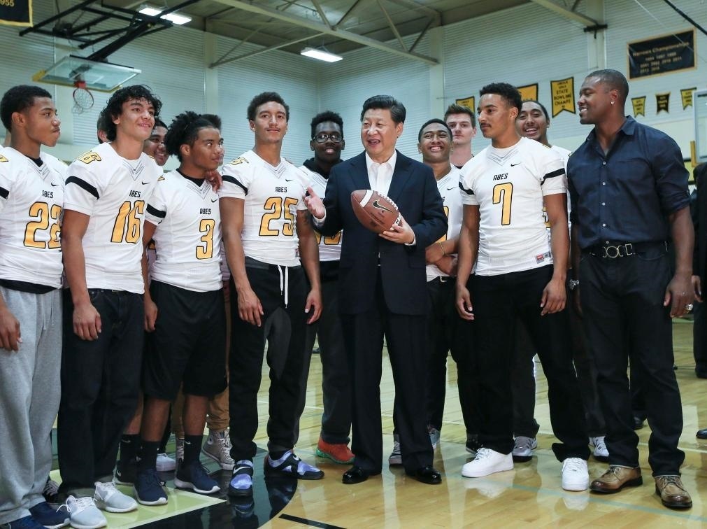 2015年9月23日，國家主席習(xí)近平參觀美國塔科馬市林肯中學(xué)。這是習(xí)近平在學(xué)校體育館，同上橄欖球訓(xùn)練課的學(xué)生們親切交談。新華社記者 蘭紅光 攝