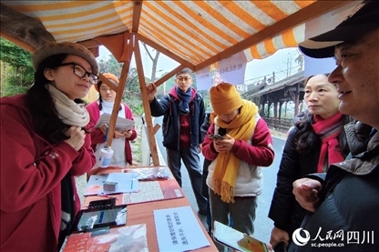 1月6日，“2024成都蒲江柑甜采摘節(jié)”上，記者見到了小萌（左一）和許多年輕人忙著做訪客接待、現(xiàn)場布置、票務(wù)核對、采摘服務(wù)等工作。人民網(wǎng)記者朱虹攝