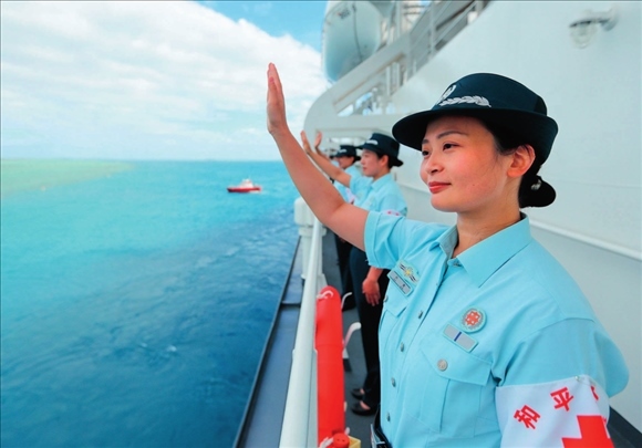 中國海軍“和平方舟”號醫(yī)院船結束訪問湯加時，任務官兵中的文職人員向歡送人群揮手告別（2023年8月4日攝）。徐巍攝/本刊