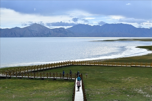 △ 游客行走在青?，敹嗫h冬格措納湖畔的木棧道上。