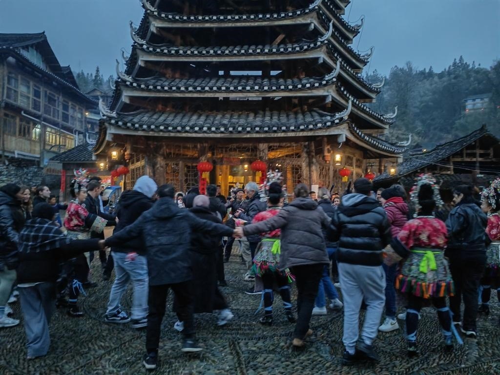 法國青年與當?shù)卮迕駹渴痔?。新華社記者 羅羽 攝