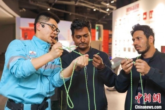 5月9日，工作人員指導留學生學習打繩結(jié)。張鷹 攝