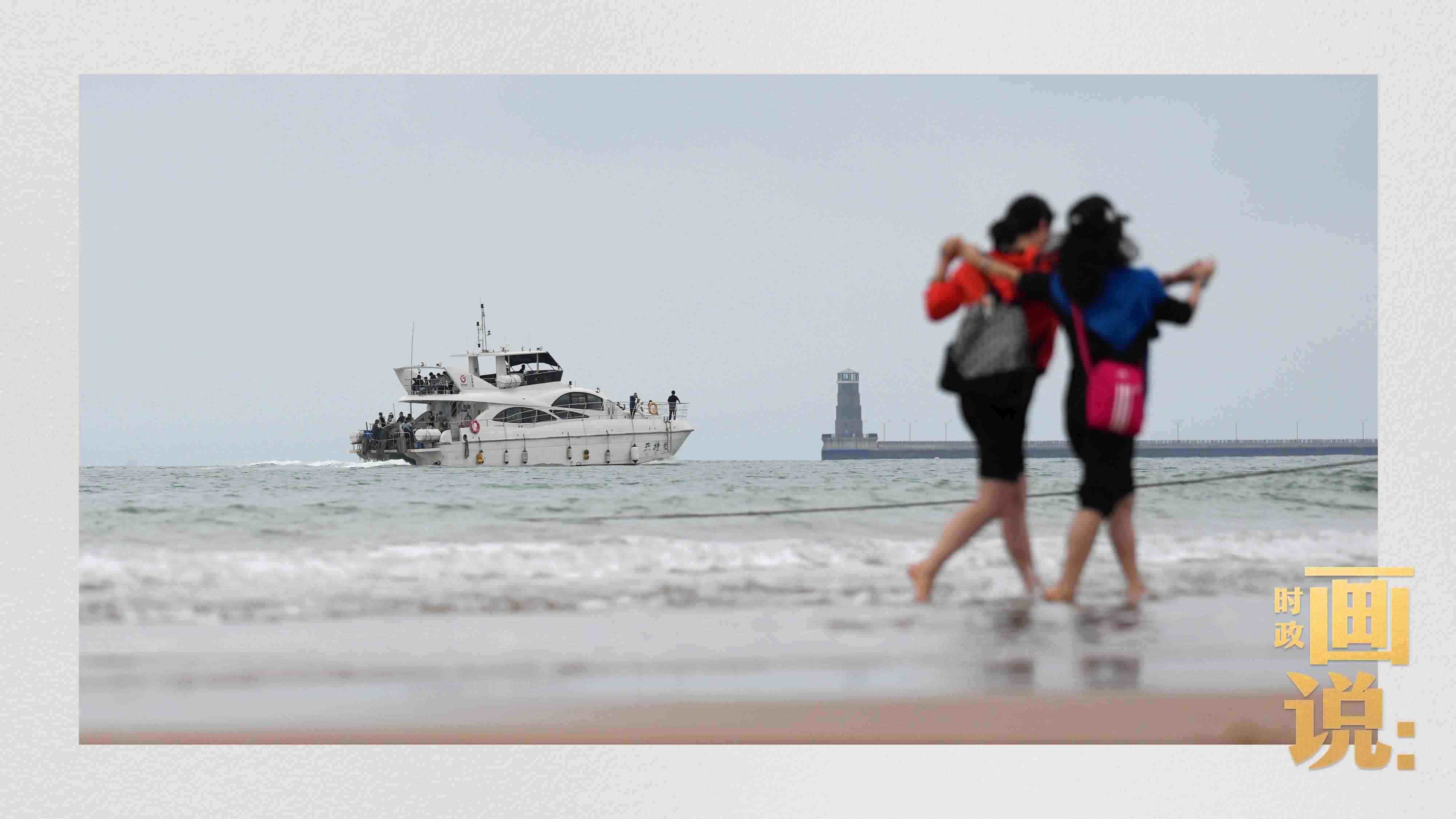 △日照陽光海岸綠道上的萬平口景區(qū)，一對(duì)游客在海浪中翩然起舞。