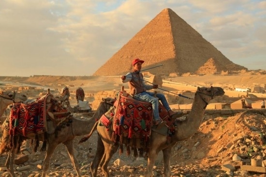 1月24日，商販騎駱駝離開埃及吉薩金字塔景區(qū)。新華社記者 隋先凱 攝