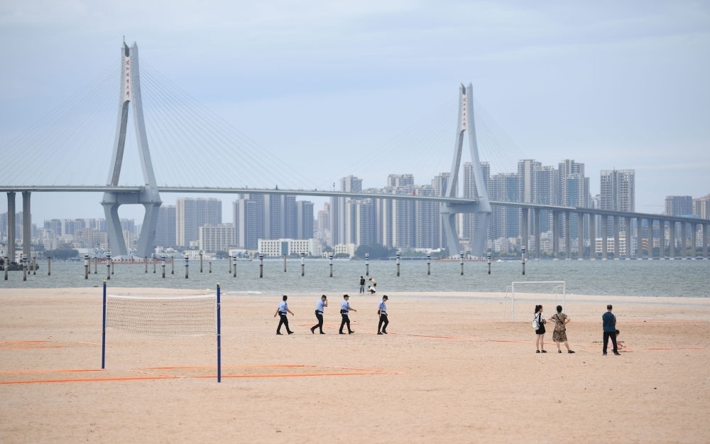 2023年7月17日，廣東湛江五環(huán)廣場(chǎng)的沙灘上，公安民警在執(zhí)勤巡邏。新華社記者 鄧華 攝
