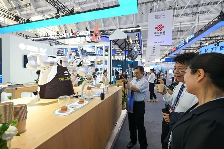 6月20日，與會者品嘗機器人沖調(diào)出的咖啡。新華社記者 孫凡越 攝