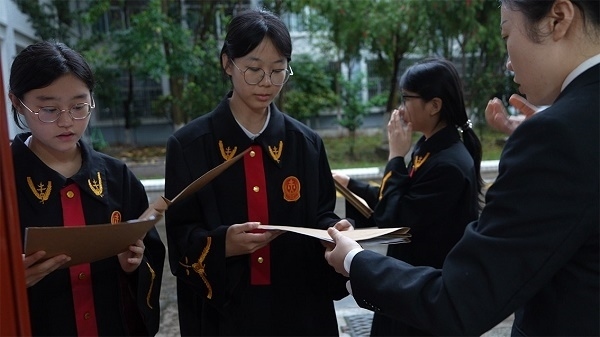 圖①：武平法院干警向?qū)W生分發(fā)道具卷宗。