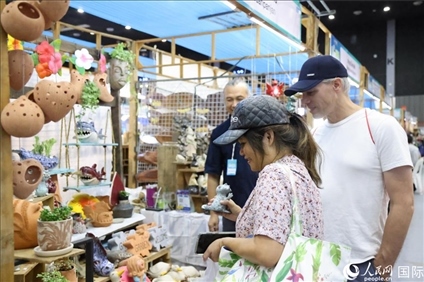 游客在蘭納博覽會特色展位上選購工藝品。人民網記者楊一攝
