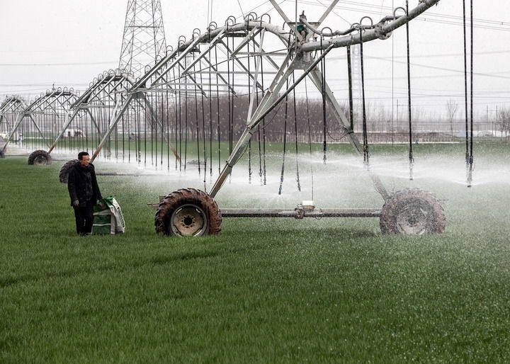 2024年3月18日，在河南省焦作市博愛(ài)縣孝敬鎮(zhèn)東原莊村瑞輝家庭農(nóng)場(chǎng)，村民使用全自動(dòng)指針式噴灌機(jī)進(jìn)行澆灌作業(yè)。新華社發(fā)（程全攝）
