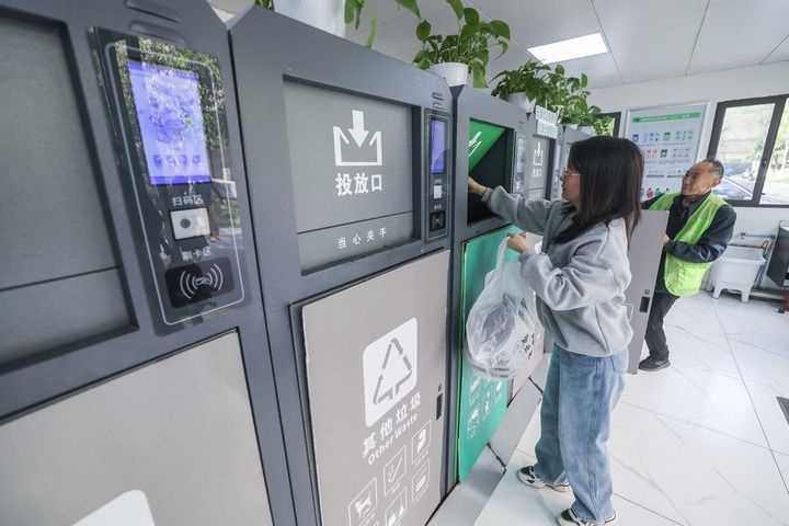 2024年4月10日，在浙江省湖州市吳興區(qū)飛英街道新華府小區(qū)內(nèi)，居民在垃圾分類智能系統(tǒng)的指導(dǎo)下進(jìn)行垃圾分類投放，居民的投放情況將實(shí)時(shí)匯總到智慧服務(wù)平臺(tái)，會(huì)有相應(yīng)的積分獎(jiǎng)勵(lì)。新華社記者 徐昱 攝